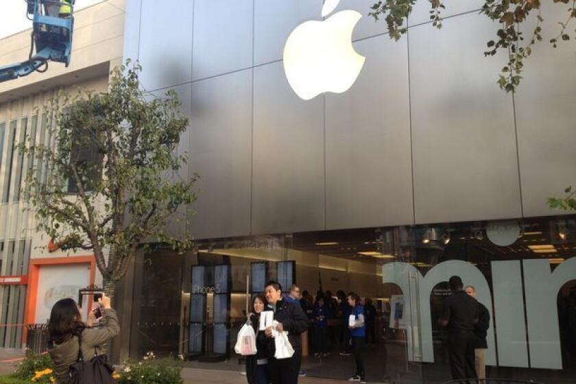 Taiwanese tourists with their new iPad minis pose for launch-day photos at the Apple store in L.A.'s Fairfax district.