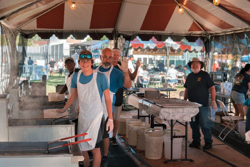 Volunteers work the fry tent at the 76th annual Costa Mesa Fish Fry and Carnival at Lions Park in 2023. 