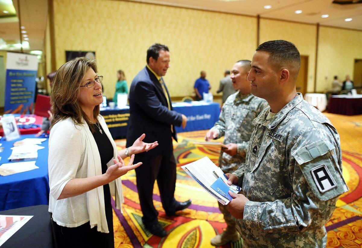 Army Master Sgt. Yeffiry Disla, right, meets with a recruiter during a job fair for veterans in Walnut Creek, Calif., in April.