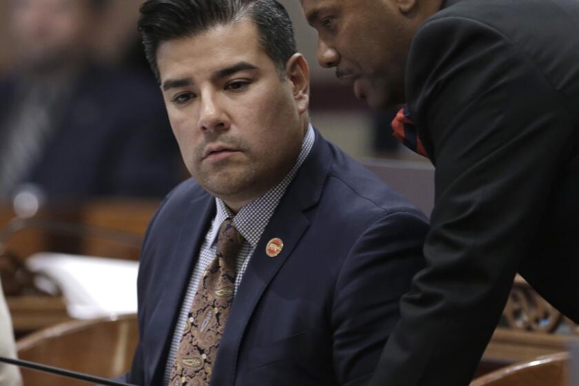 State Sen. Ricardo Lara, D-Bell Gardens, left, talks with Assemblyman Mike Gipson, D-Carson, at the Capitol, Friday, Sept. 4, 2015, in Sacramento, Calif. Lara has dropped his efforts to seek a federal wavier to allow people in the country illegally to buy unsubsidized private health coverage through Covered California. (AP Photo/Rich Pedroncelli)
