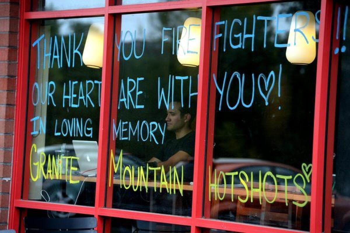 Writing on a restaurant window in Prescott, Ariz., reads, "Thank You Firefighters!! Our Hearts are with you. In Loving Memory. Granite Mountain Hotshots."