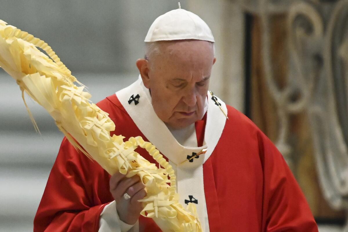 El papa Francisco sostiene una rama de palma mientras celebra la misa del Domingo de Ramos en una Basílica de San Pedro vacía, en el Vaticano, el domingo 5 de abril de 2020. (AP Foto/pool/Alberto Pizzoli)