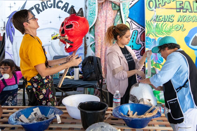 LOS ANGELES, CA - OCTOBER 26, 2019: Kristen Johannesen, Olivia Ramos and her mother Dora Magaña, from left, work on paper mache skulls for Day of the Dead at the Self Help Graphics Community Arts Workshop. (Michael Owen Baker / For The Times)