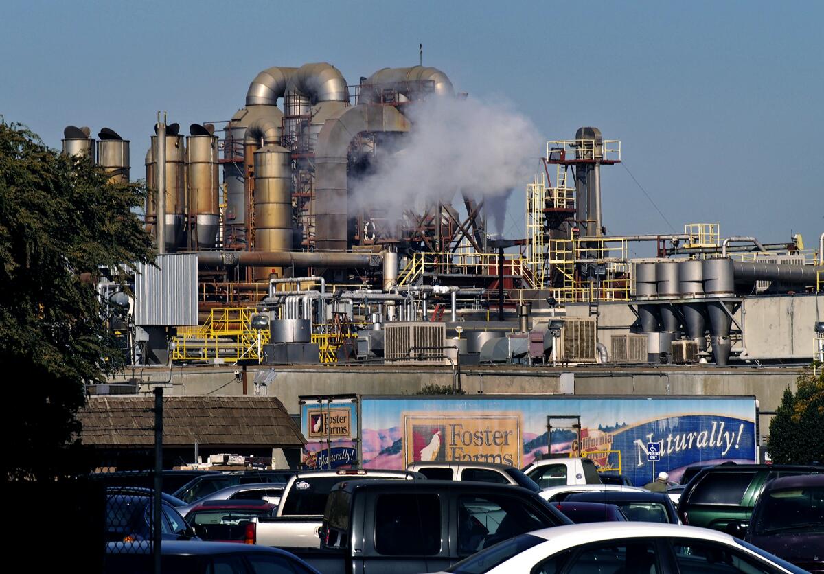 Automobiles parked outside a Foster Farms plant in Livingston, Calif.