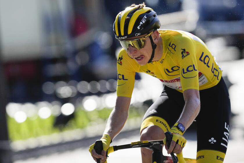 Slovenia's Tadej Pogacar, wearing the overall leader's yellow jersey, strains during the twenty-first and last stage of the Tour de France cycling race over 108.4 kilometers (67.4 miles) with start in Chatou and finish on the Champs Elysees in Paris, France,Sunday, July 18, 2021. (AP Photo/Christophe Ena)