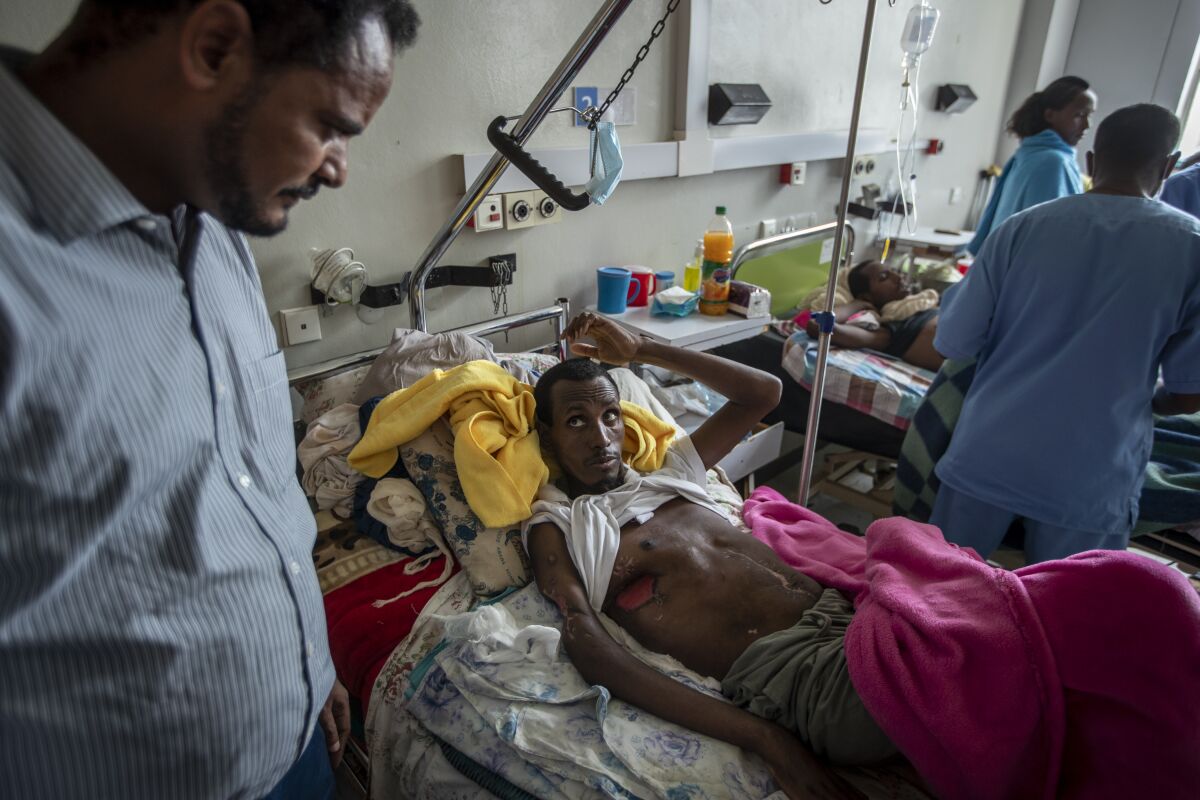 A man who said he was shot by Eritrean forces speaks to a doctor at a hospital.