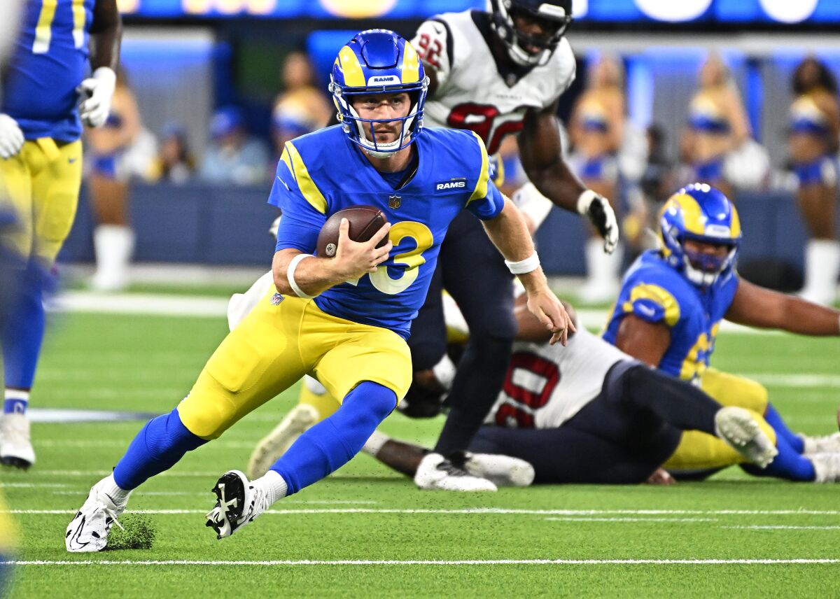 Rams quarterback John Wolford is fighting for a first down against the Texans last season.