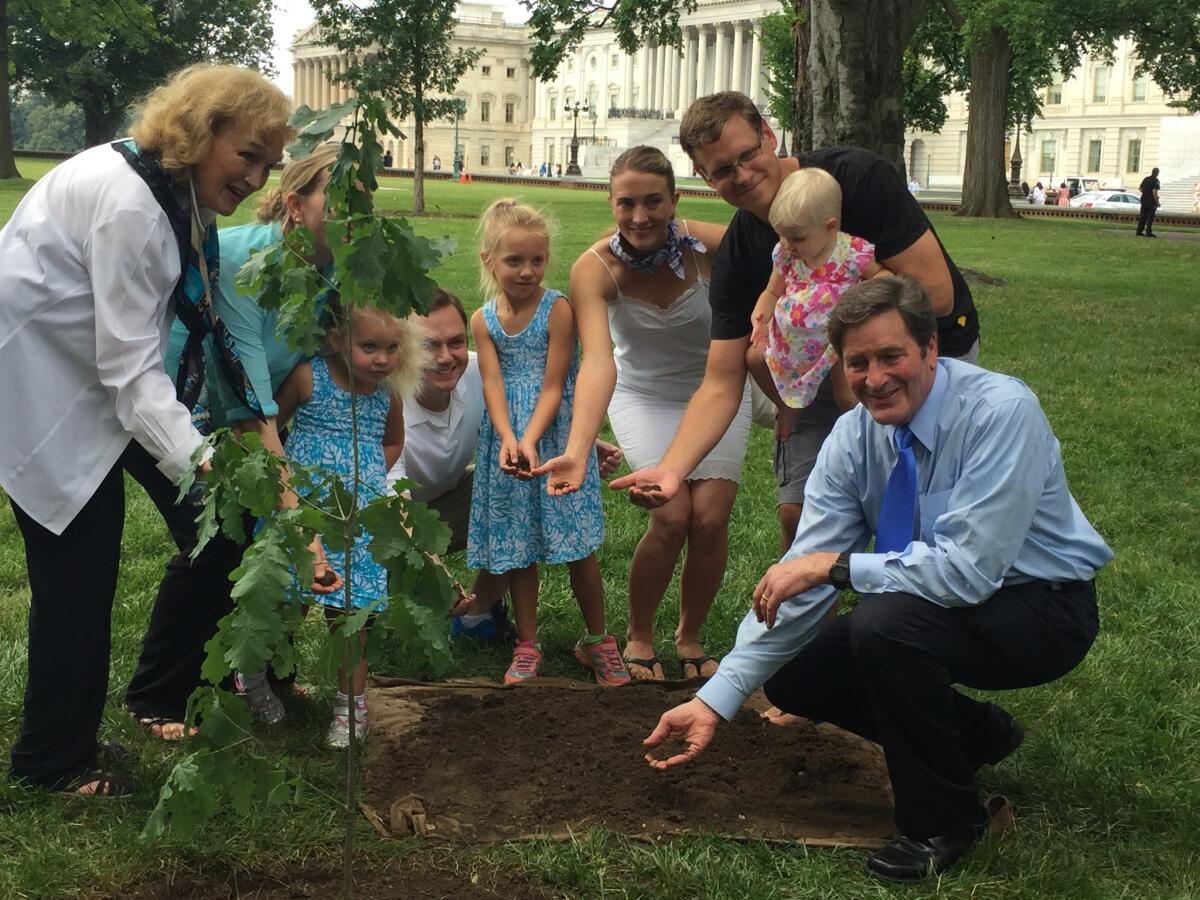 Rep. John Garamendi (bottom right) and his family cover the roots of an oak tree on Capitol Hill. The sapling is a descendant of a historic tree in the Basque Country.
