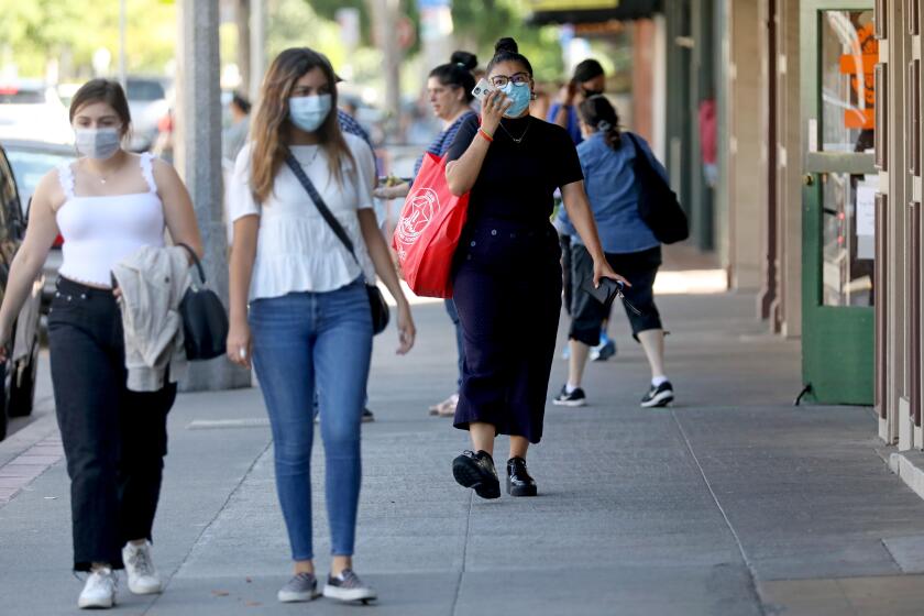 ORANGE, CA - JUNE 18: People shopping and strolling at the Orange Circle on Thursday, June 18, 2020 in Orange, CA. Gov. Gavin Newsom on Thursday ordered all Californians to wear face coverings while in public or high-risk settings due to coronavirus. Orange County recently did not require face mask to be worn. (Gary Coronado / Los Angeles Times)