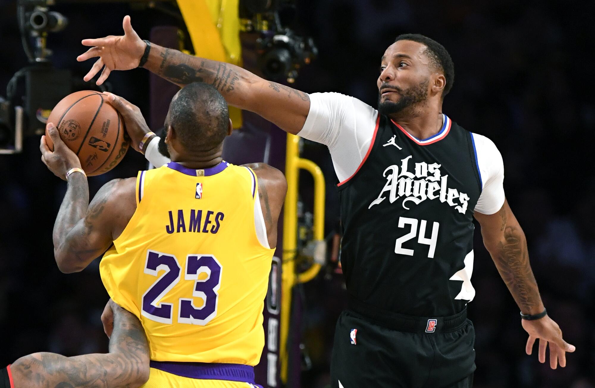 Clippers guard Norman Powell tries to block a layup by Lakers forward LeBron James.