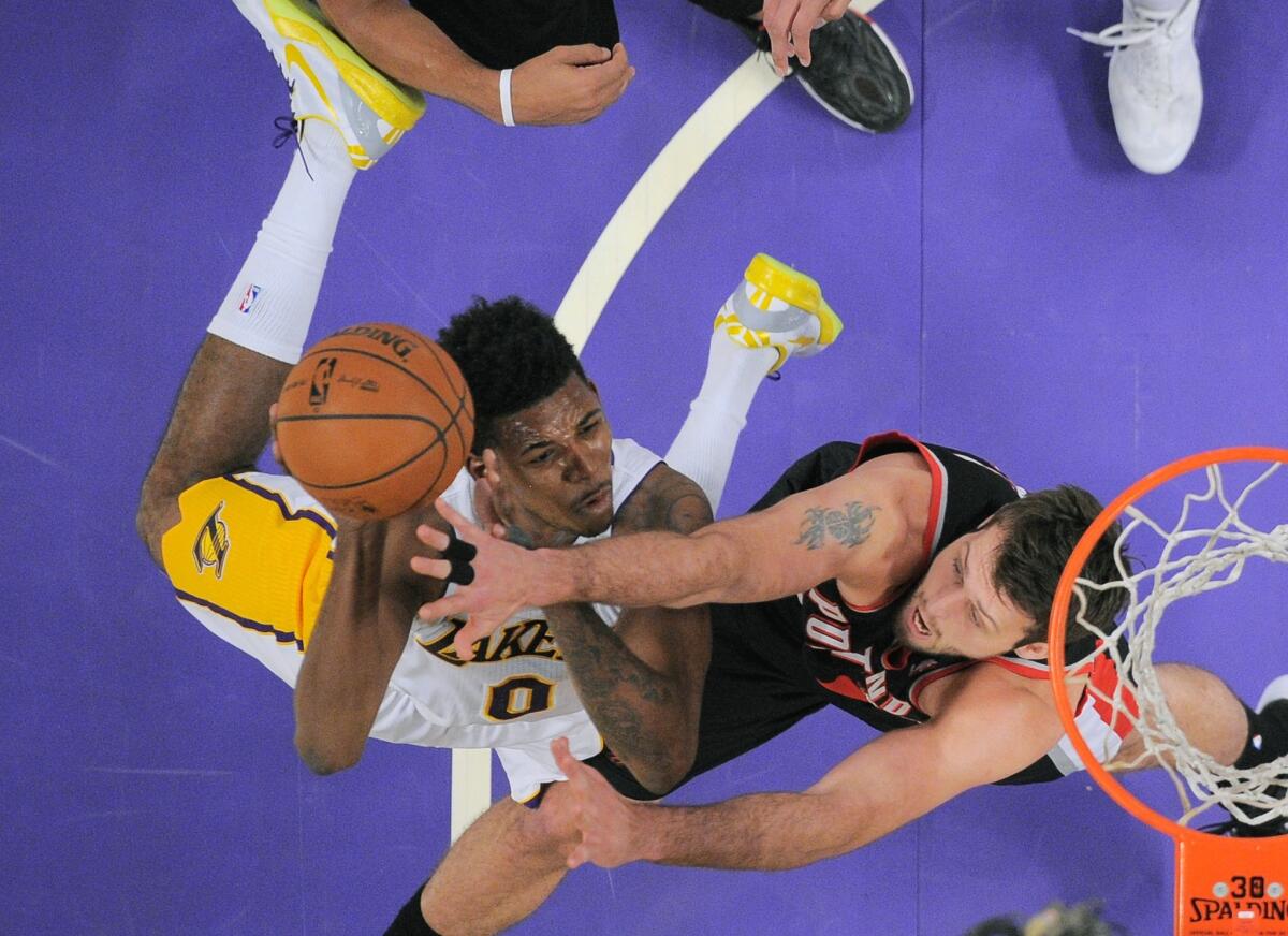 Lakers forward Nick Young, left, puts up a shot as Portland Trail Blazers center Joel Freeland defends during Sunday's game at Staples Center.