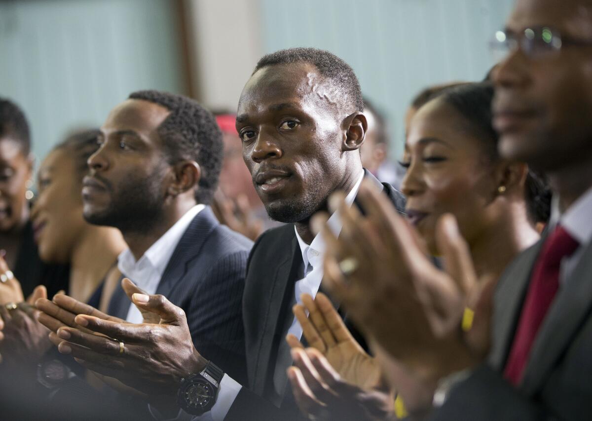 Jamaican track and field sprinter Usain Bolt applauds as he listens to President Obama at a town hall meeting at the University of the West Indies in Kingston, Jamaica, on Thursday.