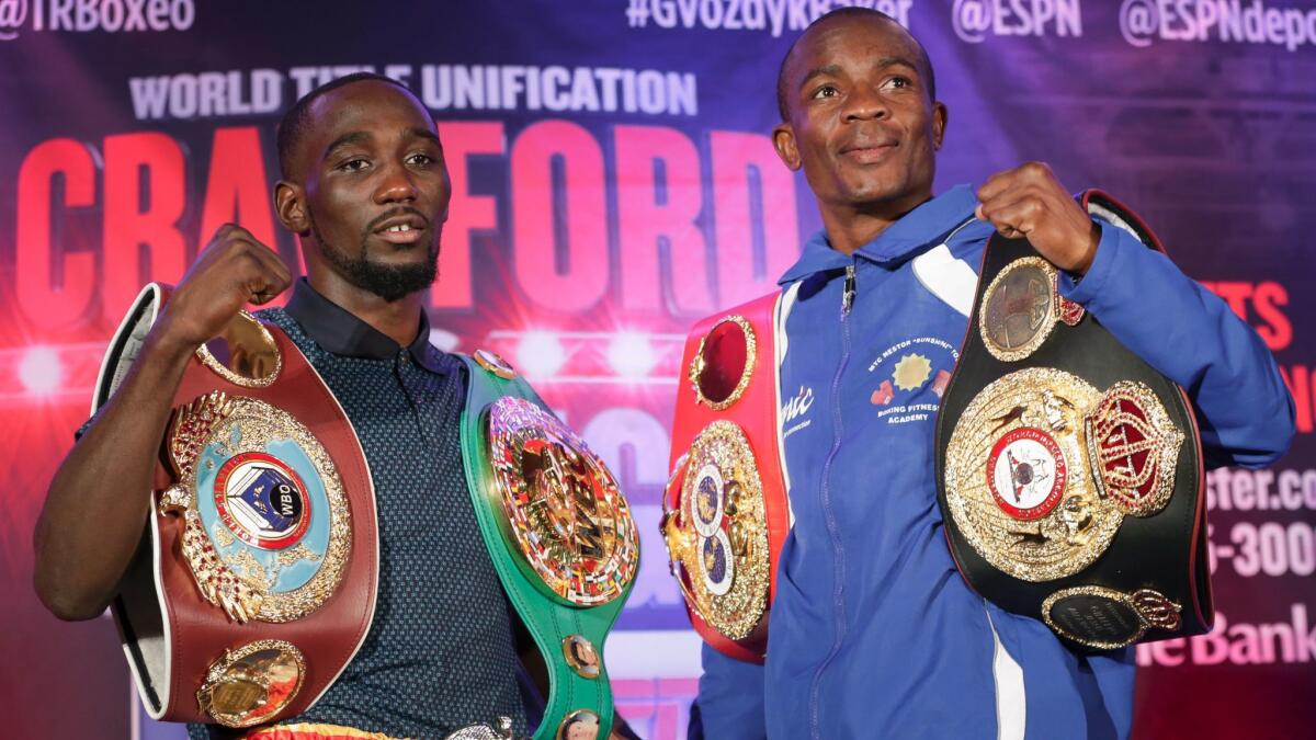Terence Crawford, left, and Julius Indongo pose with their championship belts during a news conference in Omaha, Neb., on Aug. 17.