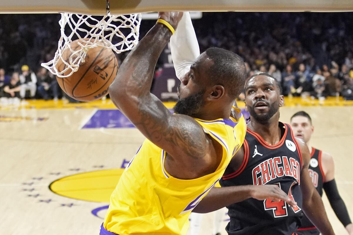 LeBron James, de los Lakers de Los Ángeles, realiza una clavada frente a Patrick Williams, de los Bulls