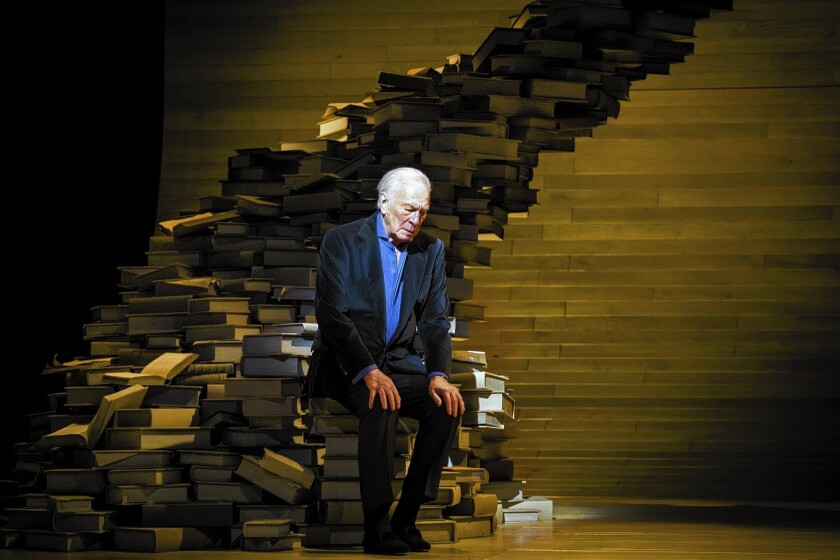 Christopher Plummer sits on a pile of books in his one-man show, "A Word or Two."