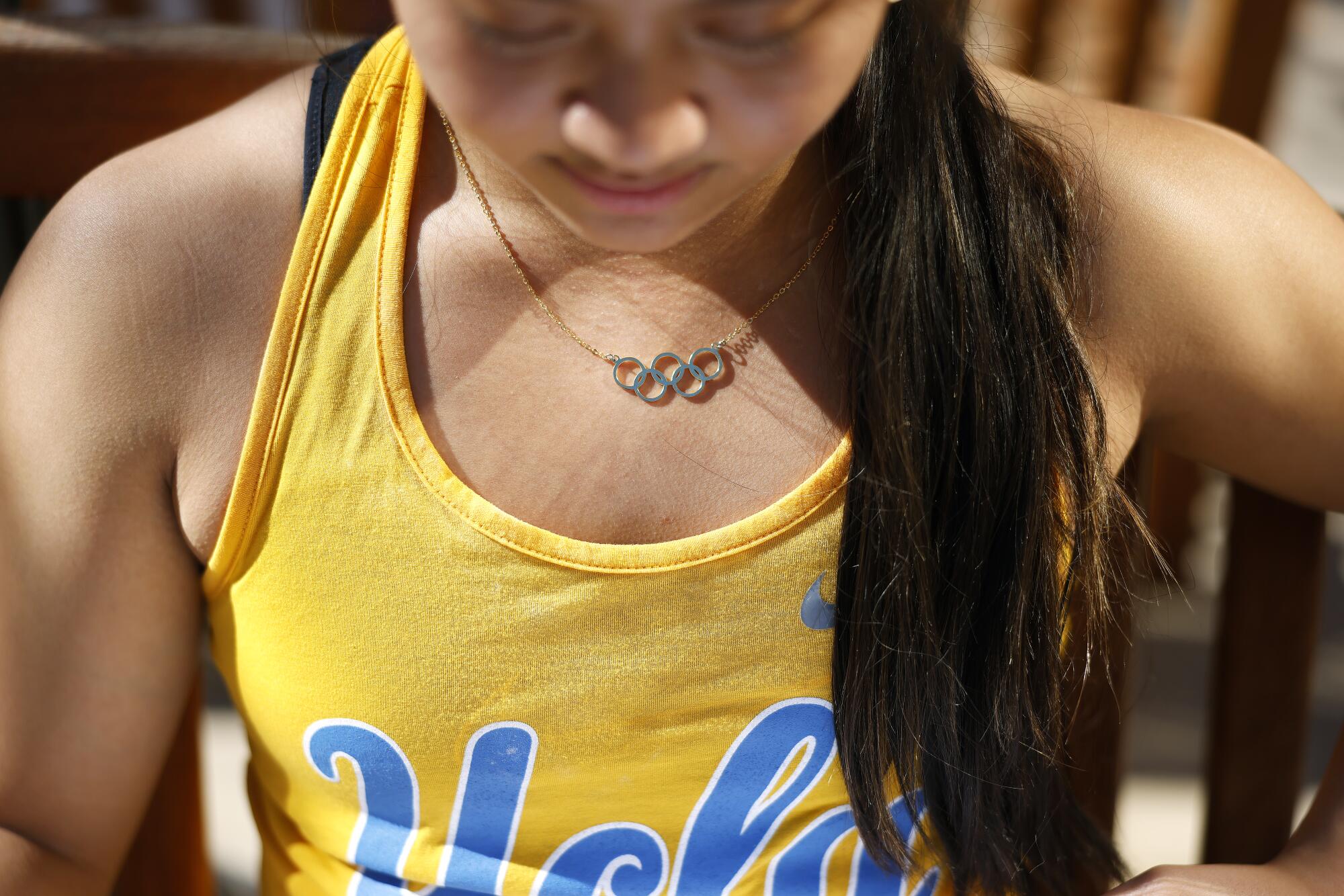 Emma Malabuyo wears a gold necklace featuring Olympic rings.