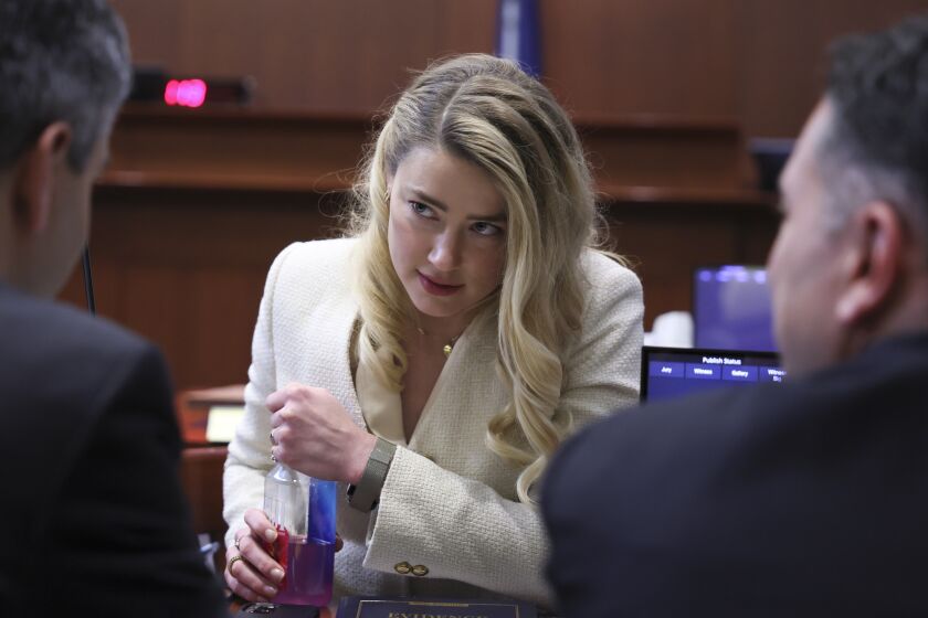 Amber Heard talks to two of her attorneys in a Virginia courtroom