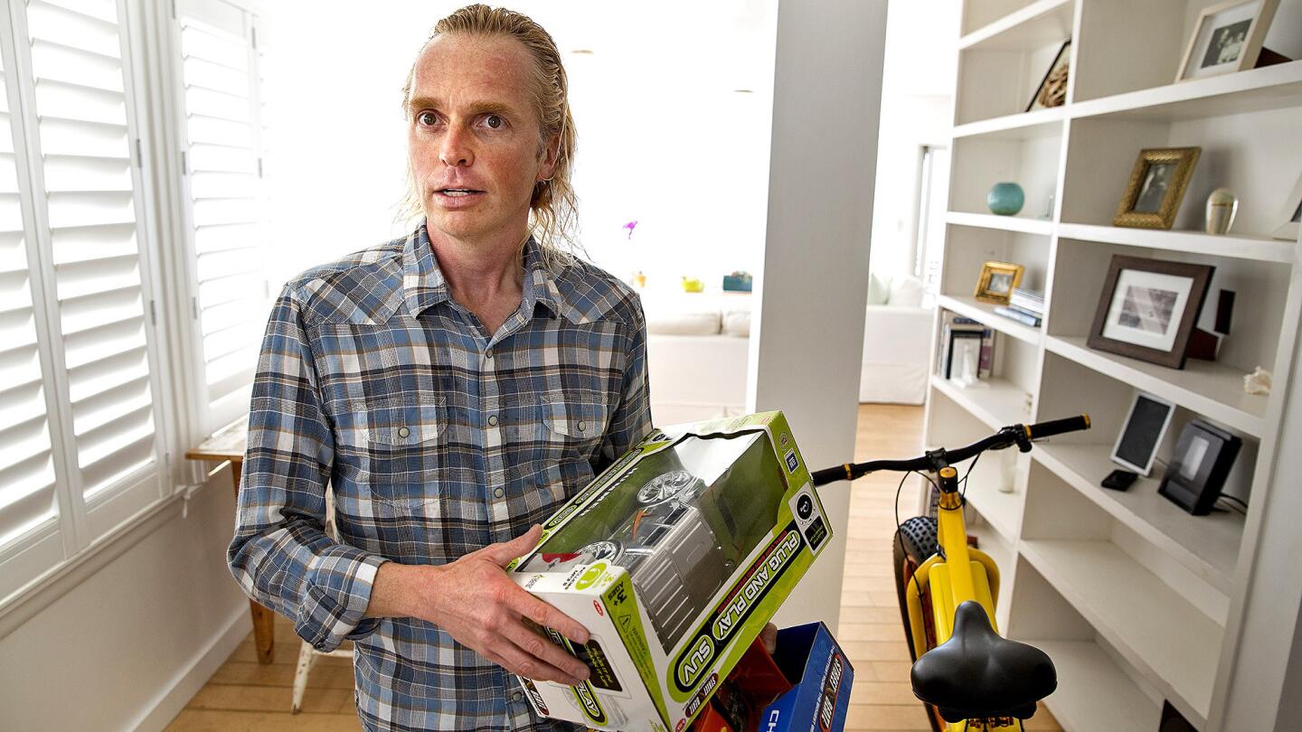 Storm Sonders holds toy cars that he designed at his Malibu home. He was 38 when a therapist identified his condition as Asperger's syndrome three years ago.