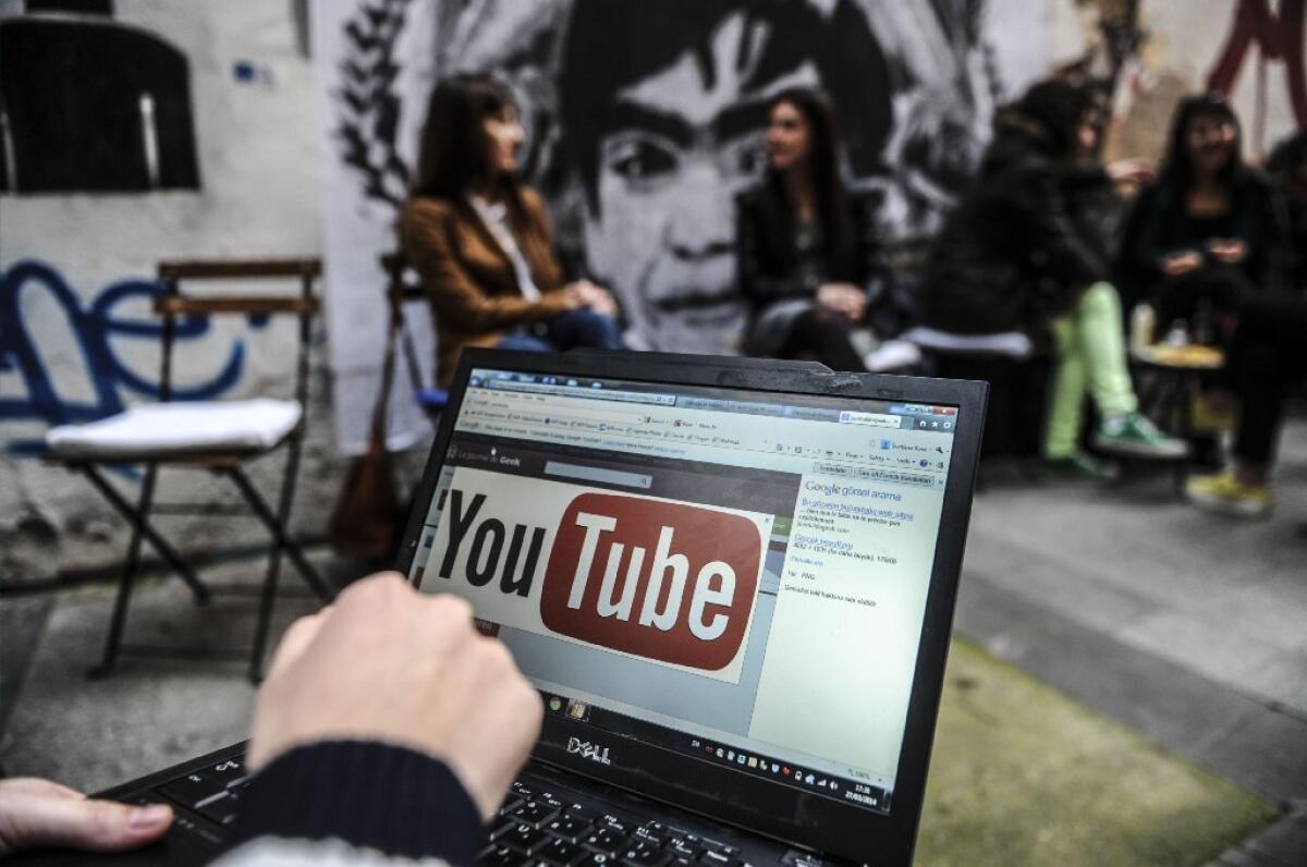 A person is seen using a laptop showing Youtube's logo.