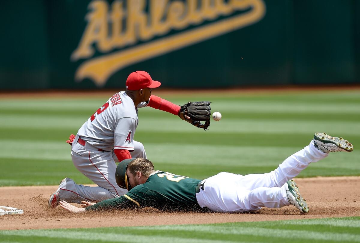 Oakland's Stephen Vogt dives into second base, beating the throw to Angels' Erick Aybar.