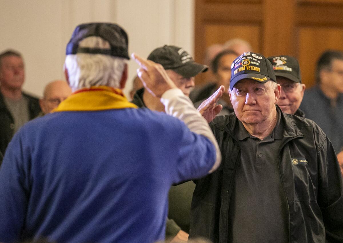 Two Vietnam veterans salute each other at a panel of former POWs. 
