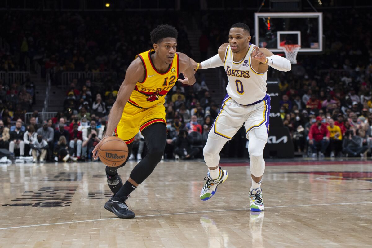 Atlanta Hawks forward De'Andre Hunter dribbles past Lakers guard Russell Westbrook.
