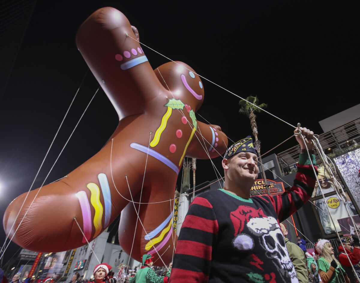 A four-story high pirate balloon floats down a road as part of a parade.