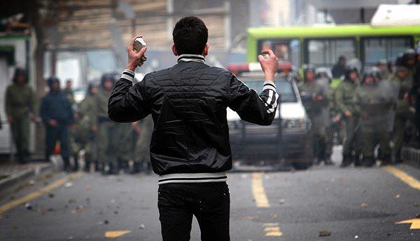 An opposition demonstrator armed with stones faces off with security forces in the Iranian capital, where clashes between police and protesters coincided with the Shiite Muslim religious holiday of Ashura.