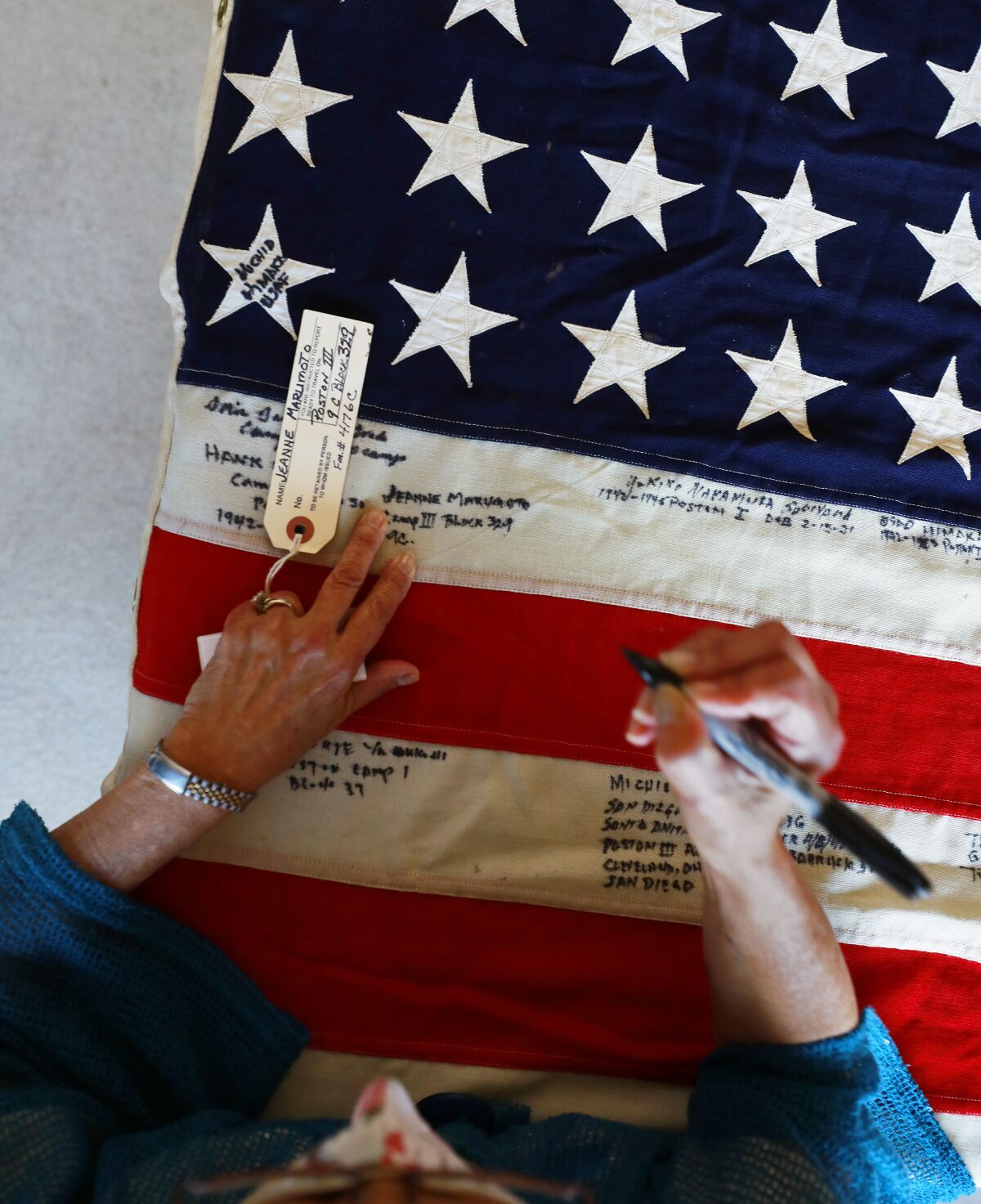 Here, Jeanne Elyea signs the flag at the Buddhist Temple of San Diego on Sunday.