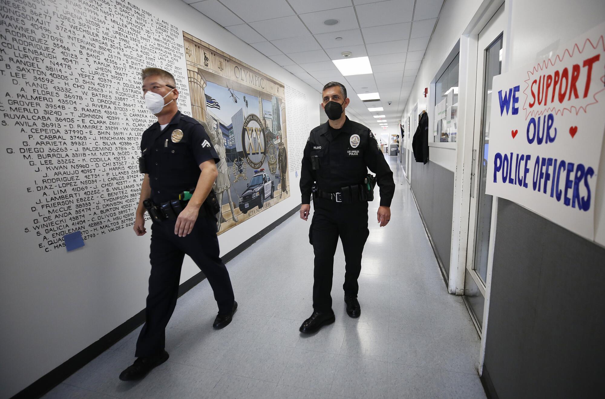 LAPD Olympic Division senior lead officers Harry Cho, left, and Joseph Pelayo in the back hallways of the Olympic station.