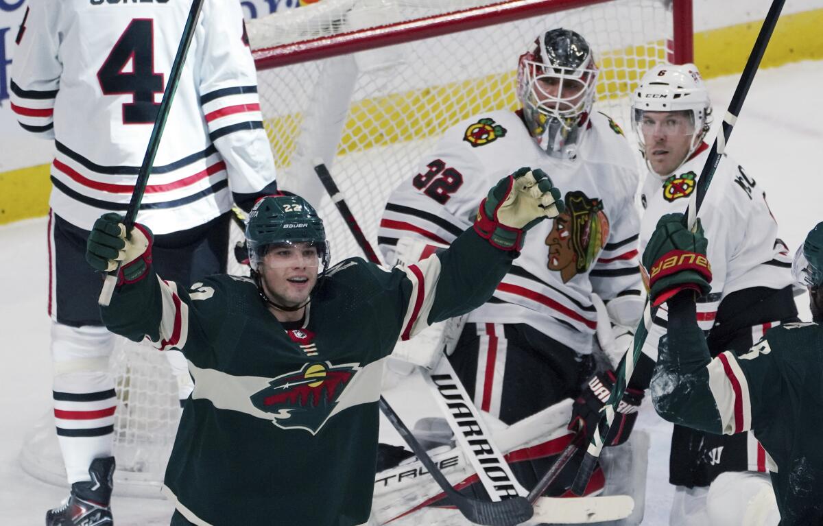 Minnesota Wild's Kevin Fiala, left, celebrates his goal against Chicago Blackhawks goalie Kevin Lankinen (32) during the third period of an NHL hockey game Saturday, Jan. 22, 2022, in St. Paul, Minn. The Wild won 4-3 in overtime. (AP Photo/Jim Mone)