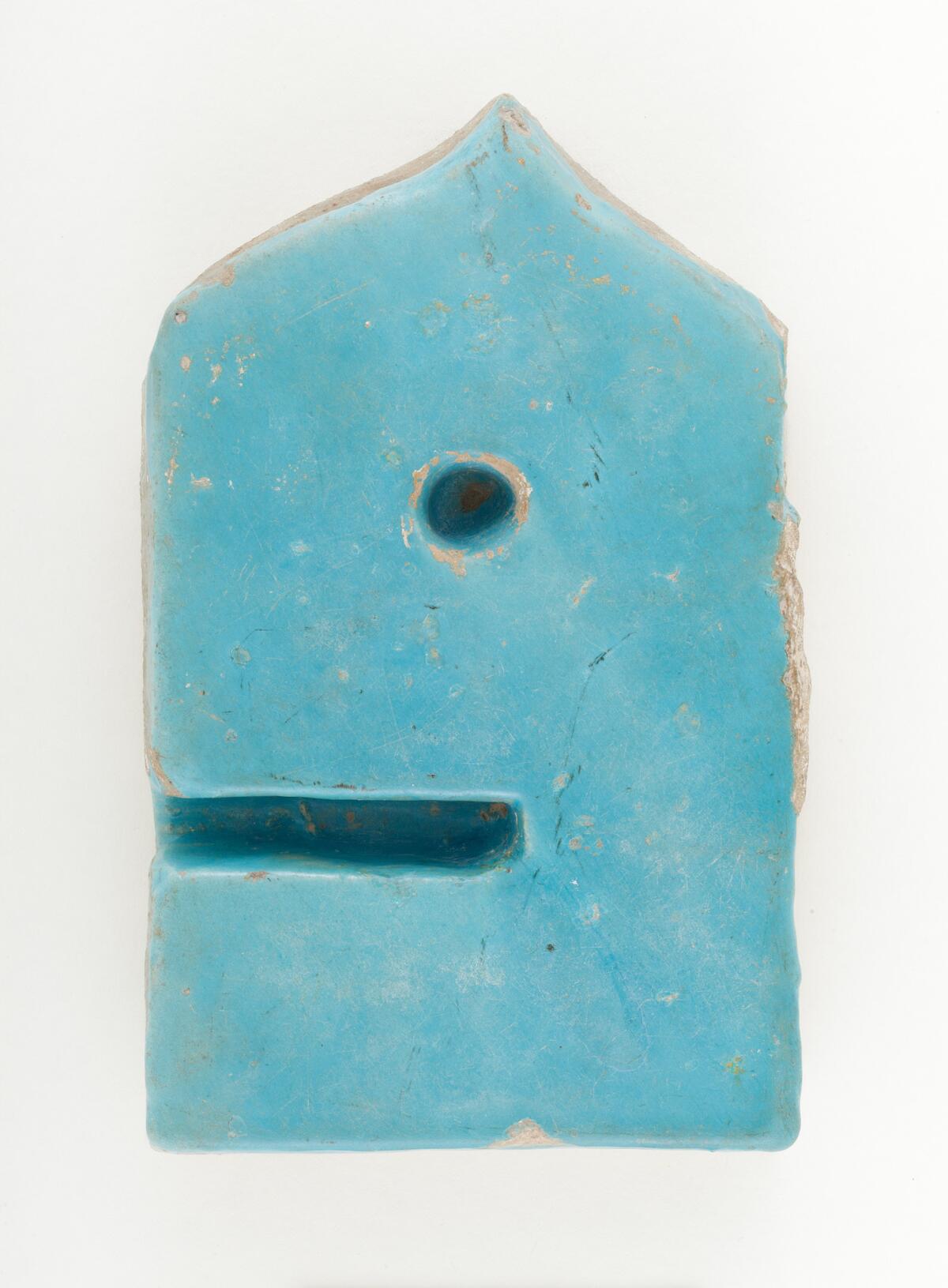 A 12th century ceramic tile in the form of the Arabic letter "Waw." This piece, which feels so contemporary in its design, would have served as part of an architectural inscription on a building.