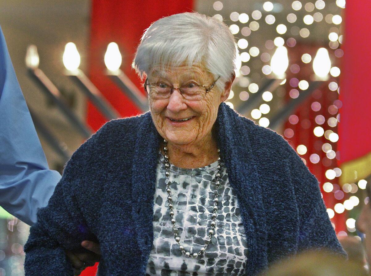 Kindt Susanne Goldsmith smiles as she is helped off the stage to participate in a group photo at recognition of the 75th anniversary of the first Kindertransport at the Burbank Town Center on Monday, December 2, 2013. Kindertransport moved as many as 10,000 Jewish refugee children to safety from the Nazis by train and ship, mostly to England, from Vienna, Berlin, Prague and other major cities. Several survivors were recognized at the anniversary ceremony.