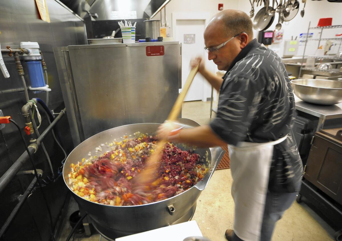 Don Morrison mixes venison and moose meat for shepherd's pie for a free dinner in Portland, Maine.