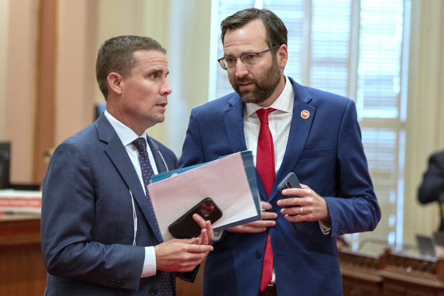 Democratic state Senators Mike McGuire, of Santa Rosa, left, and Ben Allen, of Santa Monica, right, confer at the Capitol in Sacramento, Calif., Monday, July 10, 2023. (AP Photo/Rich Pedroncelli)