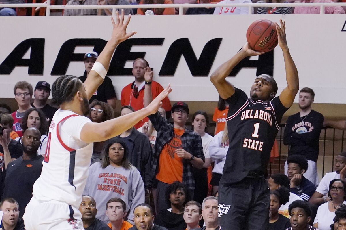 Oklahoma State guard Bryce Thompson (1) shoots over Texas Tech forward Kevin Obanor (0) in the second half of an NCAA college basketball game Saturday, March 5, 2022, in Stillwater, Okla. (AP Photo/Sue Ogrocki)
