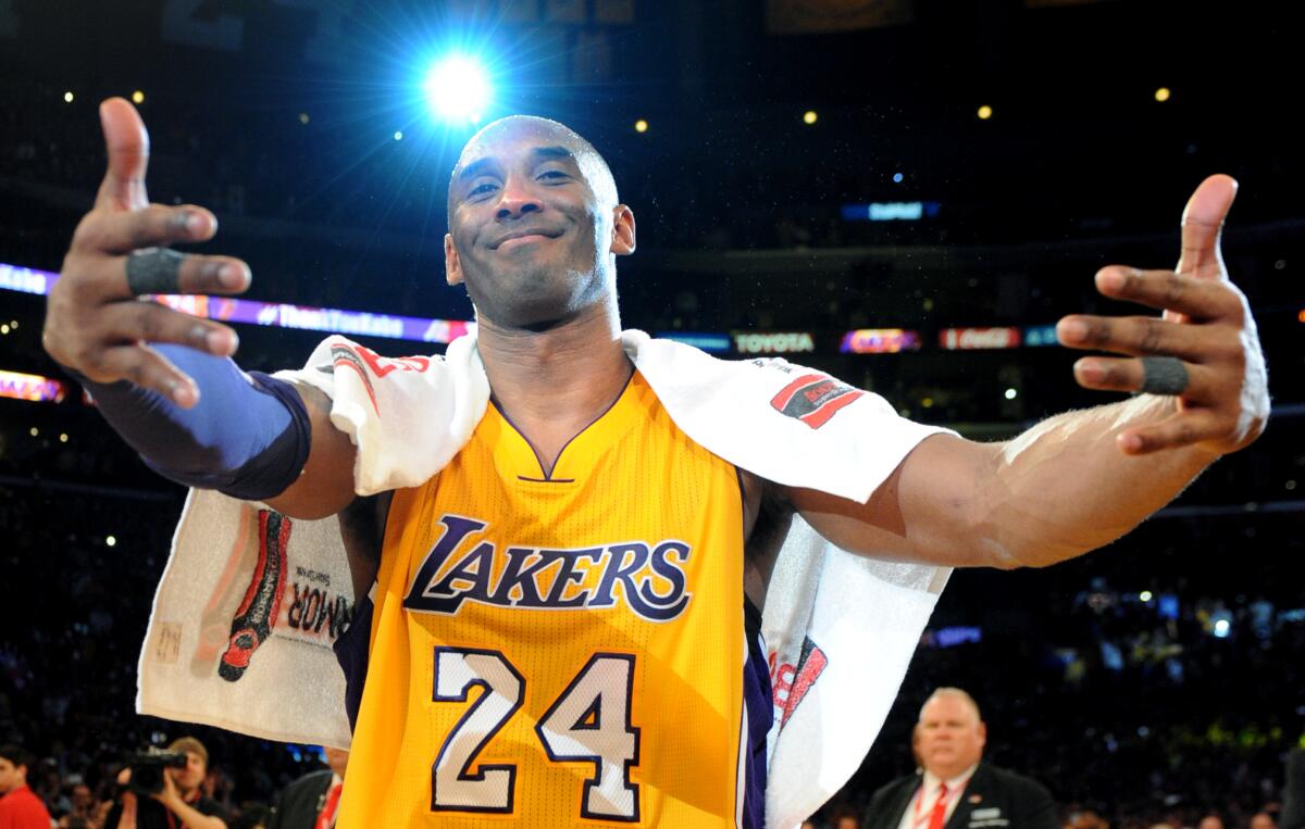 Kobe Bryant approaches his family for a hug after his final game with the Lakers on April 13, 2016.