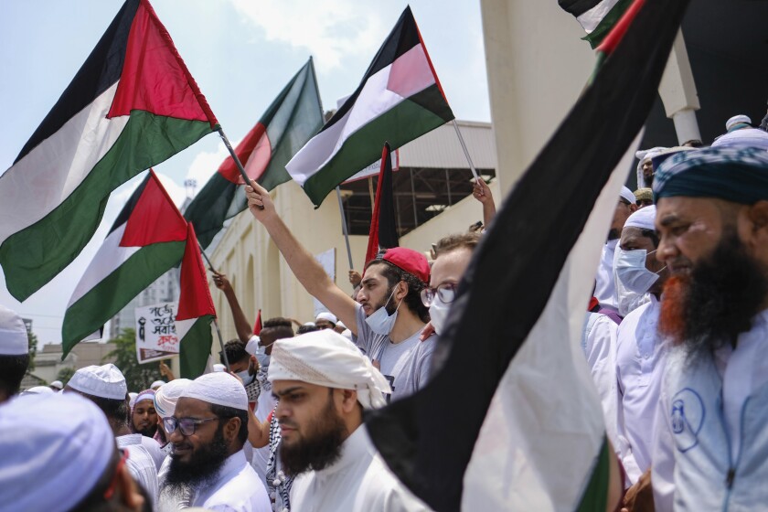 Bangladeshi Muslims protesting against Israeli attacks on Palestinians in Gaza, gather after Eid al-Fitr prayers in front of Baitul Mukarram Mosque and wave Palestinian and Bangladeshi flags in Dhaka, Bangladesh, Friday, May 14, 2021. (AP Photo/Mahmud Hossain Opu)