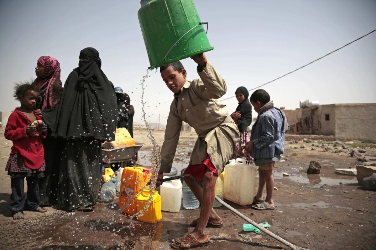 A boy rinses a bucket as he and others collect water from a well that is allegedly contaminated with cholera bacteria, on the outskirts of Sanaa, Yemen, on July 12, 2017.
