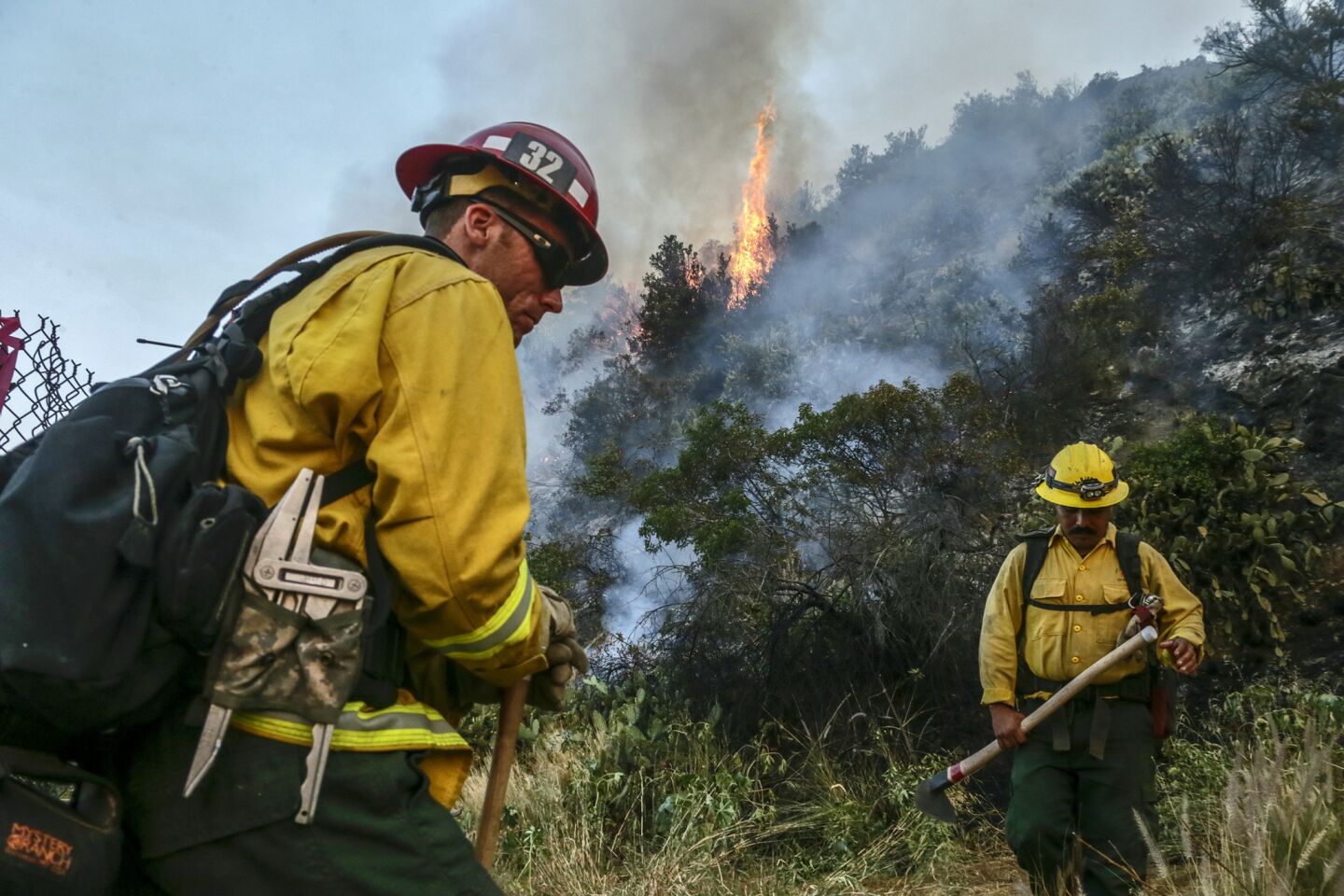 U.S. Forest Service firefighters Chris Calomino, left, and Pedro Barba are on fire watch at the 3200 block of Brookridge Road as the Fish fire burns above the hills in Duarte on Tuesday morning.