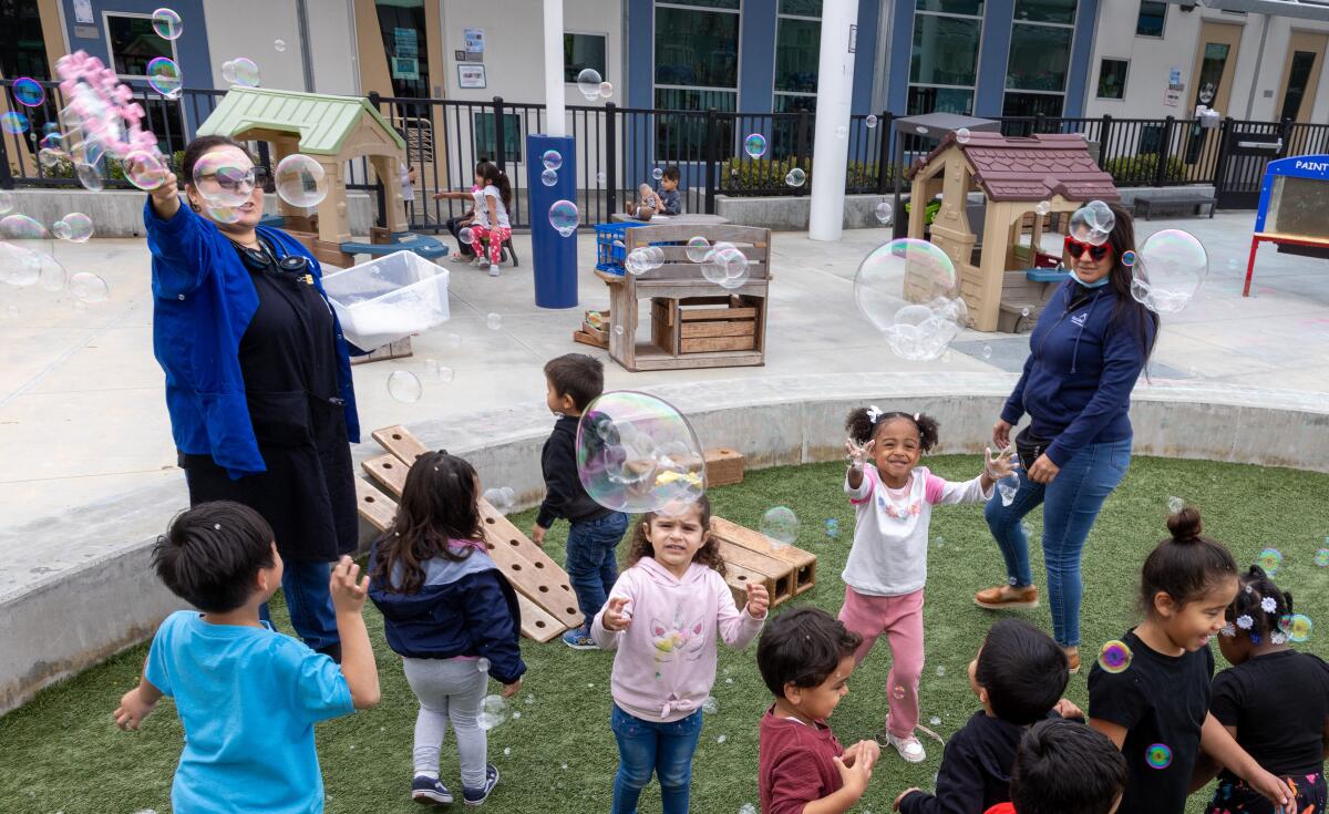 Students play with bubbles on the playground.