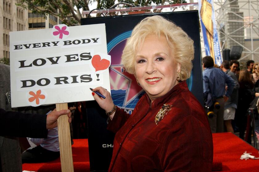 Doris Roberts autographs a sign during the Feb. 10, 2003, ceremony honoring her with a star on Hollywood's Walk of Fame.