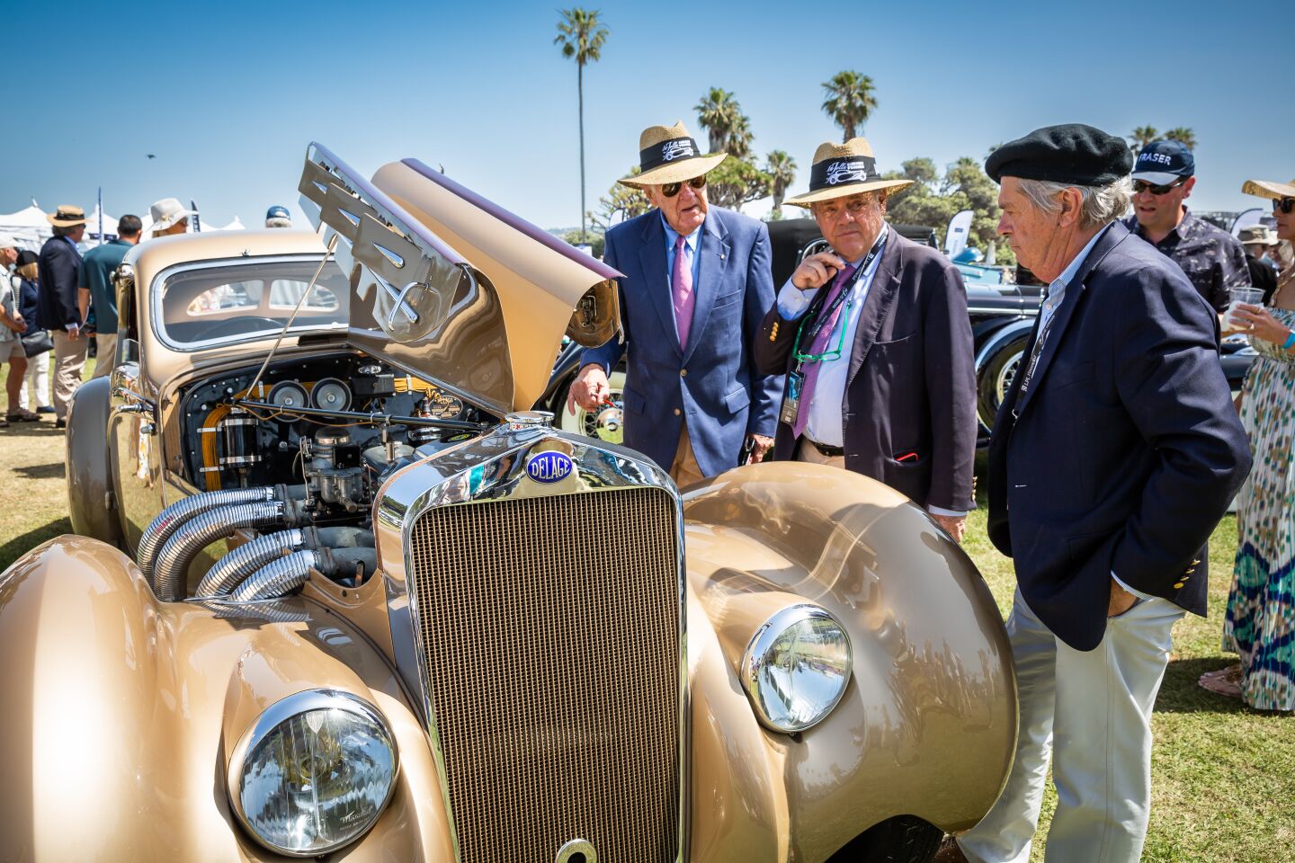 Judges Hugo Modderman and Dan Harmer talk with Dana Williamson as they peruse a 1937 Delage D8-120 Aerosport coupe from the Petersen Automotive Museum in Los Angeles.