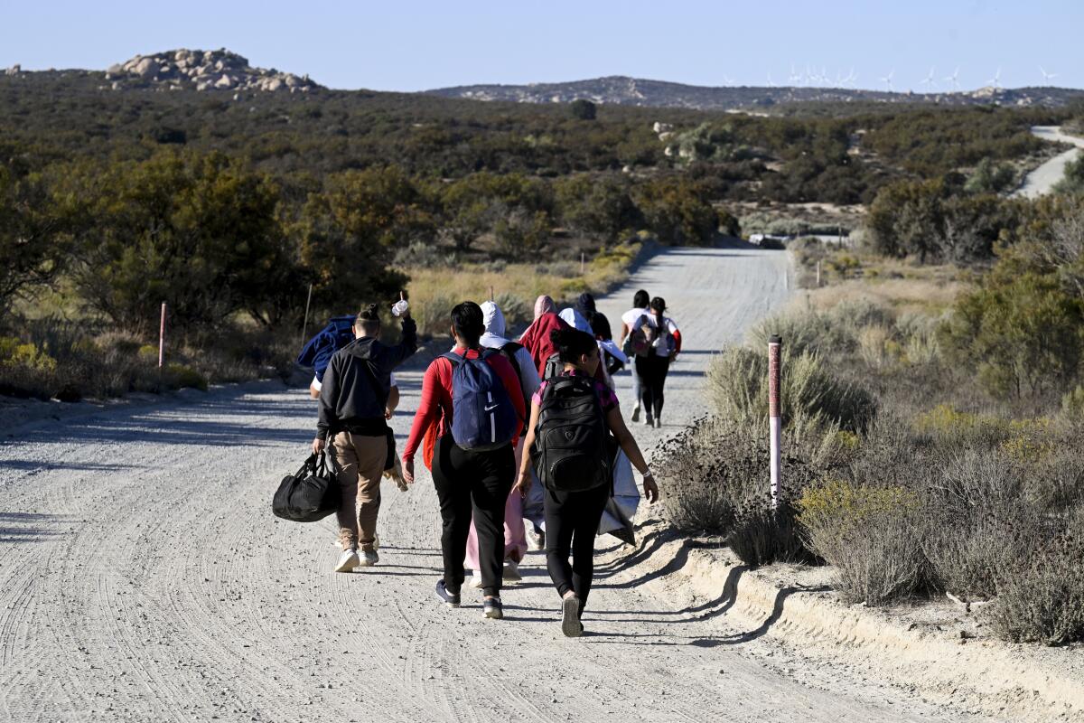 Solicitantes de asilo caminan en dirección a una camioneta de la Patrulla Fronteriza de Estados Unidos 