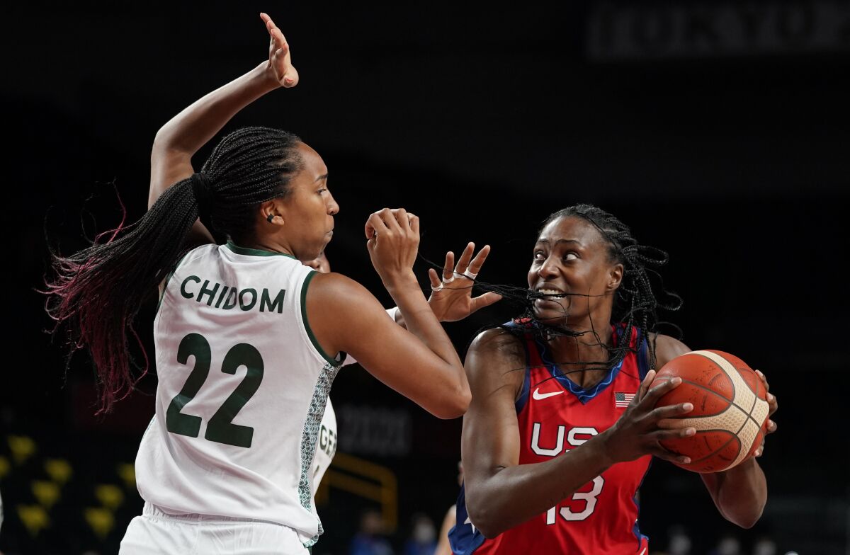 United States' Sylvia Fowles (13), right, drives past Nigeria's Oderah Chidom (22) during women's basketball preliminary round game at the 2020 Summer Olympics, Tuesday, July 27, 2021, in Saitama, Japan. (AP Photo/Charlie Neibergall)