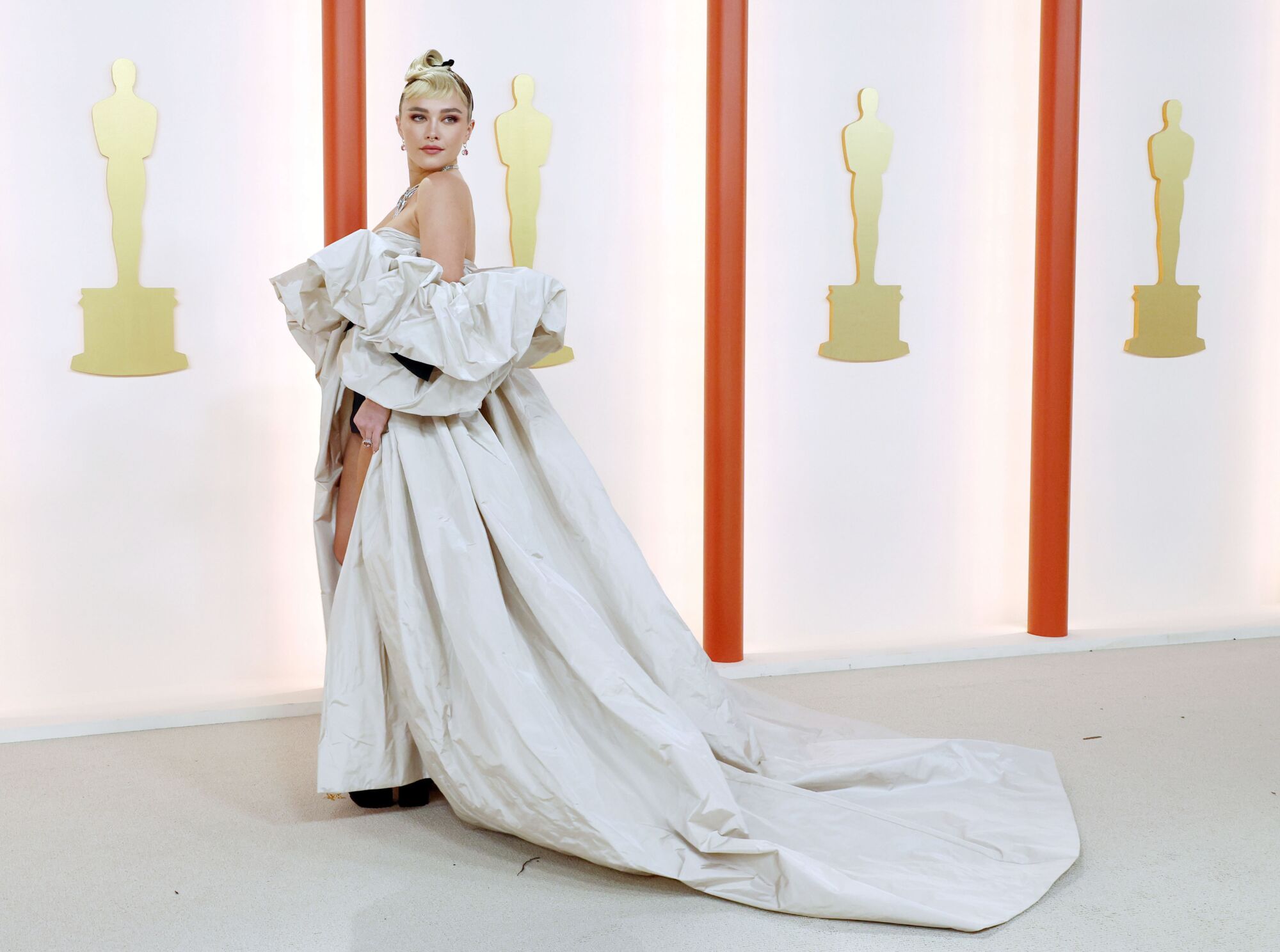 Florence Pugh in a white gown with ruched sleeves and long train.