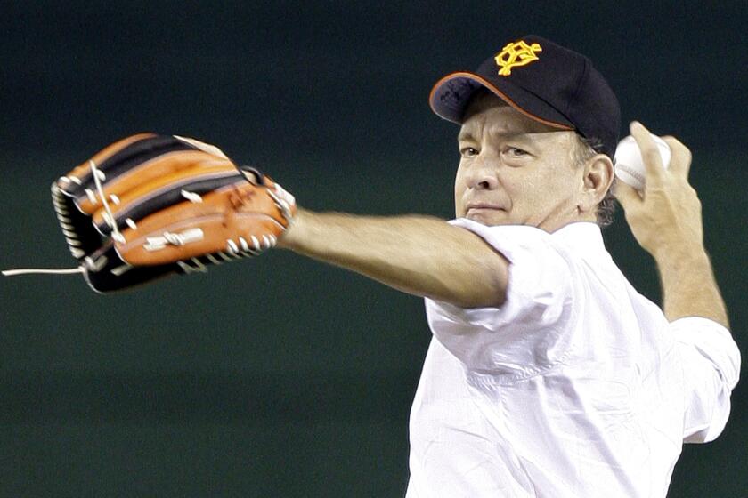 U.S. actor Tom Hanks, wearing a baseball cap of the Yomiuri Giants, throws the first pitch before the start of Japan's professional baseball game between the Giants and the Chunichi Dragons at Tokyo Dome in Tokyo, Japan, Friday, May 8, 2009. Keen baseball fan Hanks is in Tokyo to promote his latest film "Angels & Demons" which will be shown around the world on May 15. (AP Photo/Koji Sasahara)