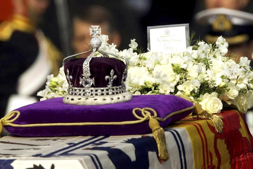 FILE - The Koh-i-noor, or "mountain of light," diamond, set in the Maltese Cross at the front of the crown made for Britain's late Queen Mother Elizabeth, is seen on her coffin, along with her personal standard, a wreath and a note from her daughter, Queen Elizabeth II, as it is drawn to London's Westminster Hall, April 5, 2002. Just hours after Queen Elizabeth II's death, Indian social media lit up with renewed calls for the return of the famous Koh-i-Noor, the 106-carat discovered in India that is part of the British crown jewels. (AP Photo/Alastair Grant, File)