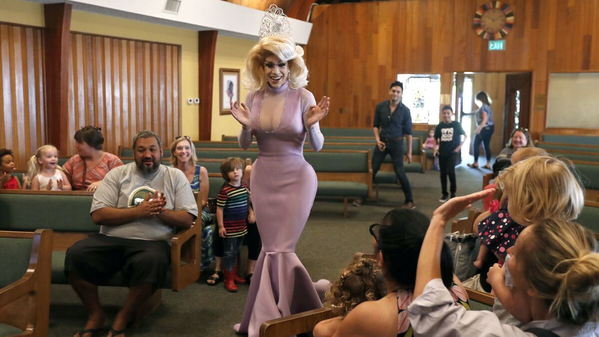 Drag queen Autumn Rose greets children and parents before reading children's books in a story time at Fairview Community Church in Costa Mesa on Wednesday.