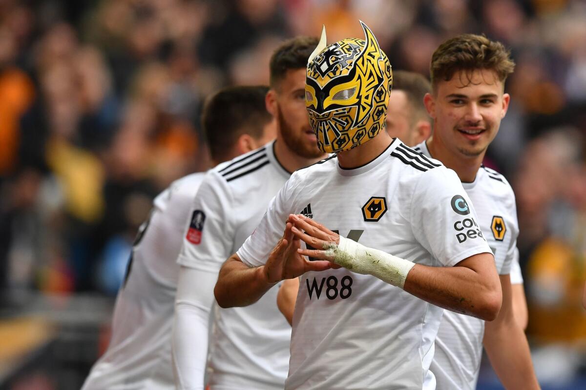 Wolverhampton Wanderers' Mexican striker Raul Jimenez (C) wears a wrestler's mask as he celebrates scoring his team's second goal during the English FA Cup semi-final football match between Watford and Wolverhampton Wanderers at Wembley Stadium in London, on April 7, 2019.